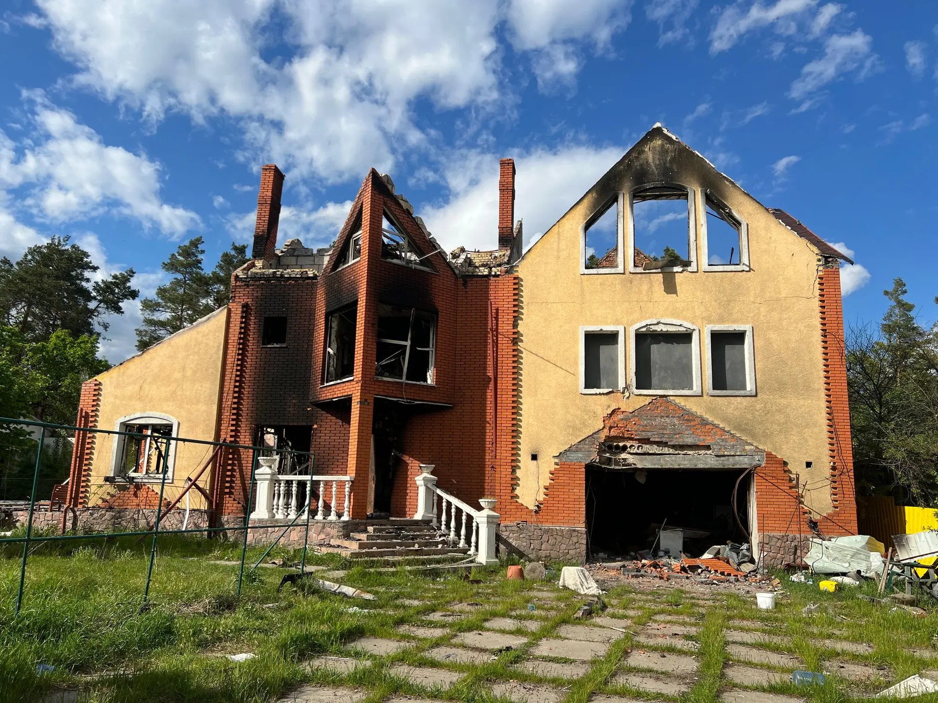 Two-story house with one burned section and its roof opened by fire