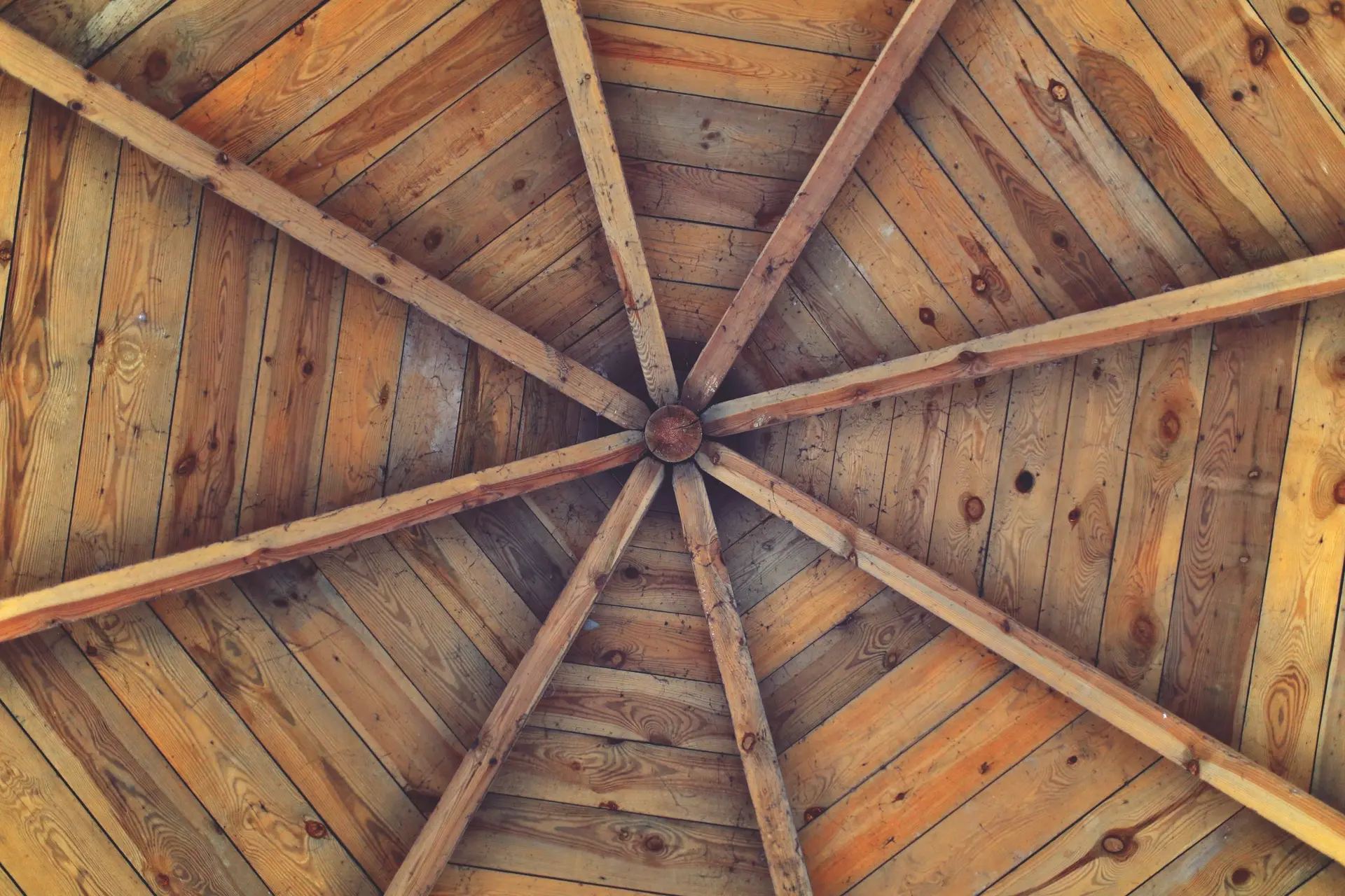 Wood ceiling with radiating rafters meeting at a center point